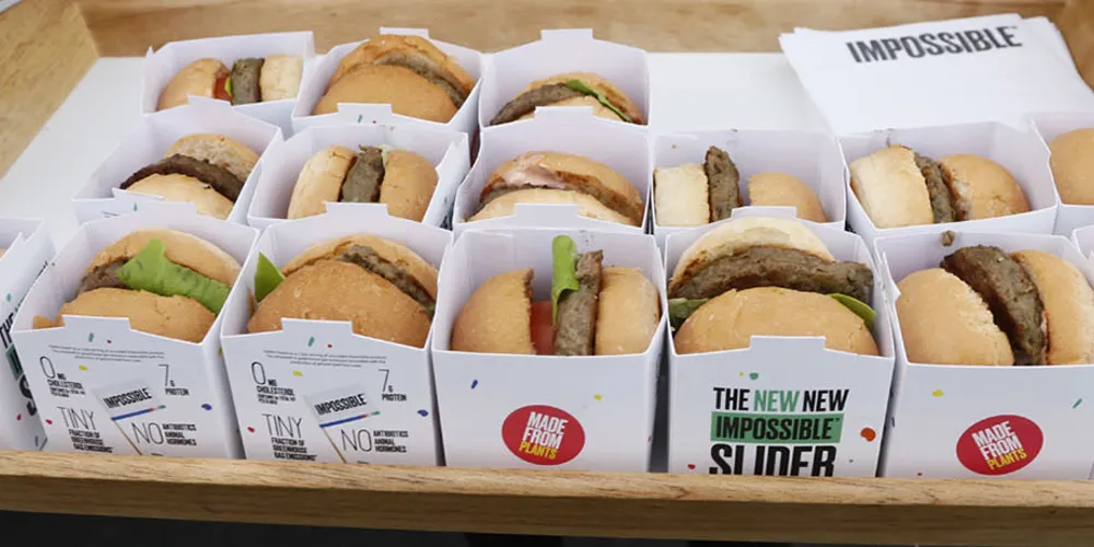ALT Text: a person holding a tray of 16 impossible burgers (fake meat) individually wrapped